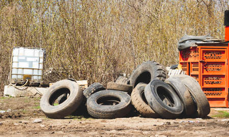 Changing car tyres. Old rubber tires in the trash. car dump. Garbage for recycling.の写真素材