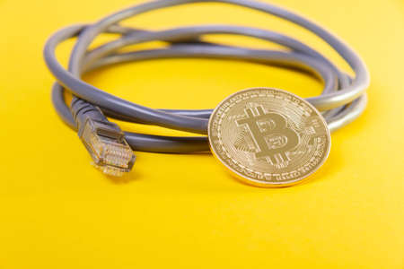 Internet payment for bitcoins. Internet cable and coin. Cryptocurrency as a means of payment. Bitcoin coin close up.の写真素材