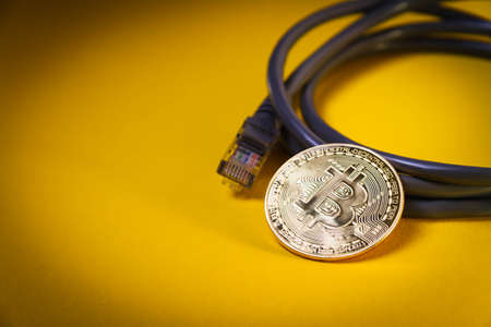 Internet payment for bitcoins. Internet cable and coin. Cryptocurrency as a means of payment. Bitcoin coin close up.の写真素材