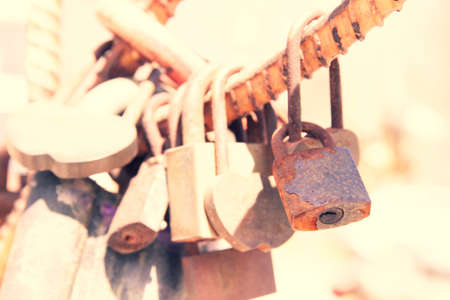 old padlock. Door lock in the form of a heart. closed door. The padlocks are on the fence.の写真素材