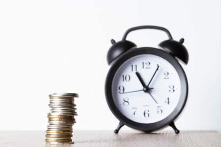 alarm clock and money. Time is money. Coins on the background of the clock. Money leak. Payment of...