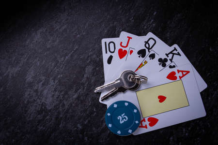 House on the line in the casino. Losing at home in poker. A winning combination in cards. Grand prize. House keys on the playing table.の写真素材