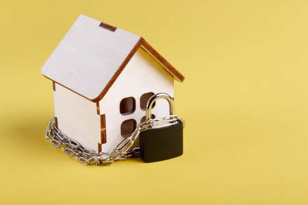 housing arrest. castle house. Small toy house and a chain with a lock. Eviction for non-payment. The locked door to the house.の写真素材