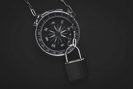 Compass and lock. Travel ban. Restriction of movement. Closed borders of countries. Canceled excursions and a ban on visiting forests. Tourist vacation.の写真素材