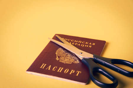 Deportation from Russia. Deprivation of citizenship. country change. Scissors cut the passport of a citizen of the Russian Federation.の写真素材