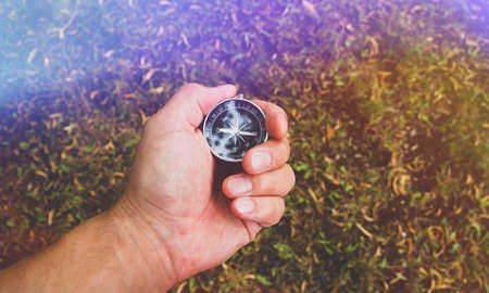 Travel and navigation. Determination of cardinal points by compass. Lost in the forest. How to find your way out with a compass. Tourists and maps.の写真素材