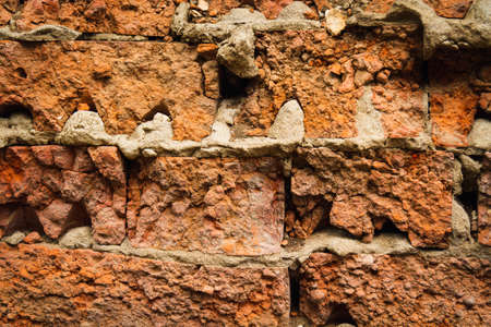 Red brick wall. Destruction after the demolition of the house. Remains of a demolished house.