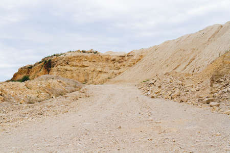 Ruins in a quarry. Dumps of clay and crushed stone in a quarry. Abandoned mine. Extraction of crushed stone by rotary excavators.の写真素材