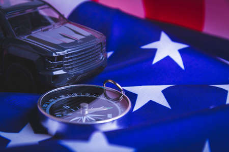 Traveling by car in the USA. Moving to America. Tourists by car. American roads. Compass, maps and usa flag.の写真素材