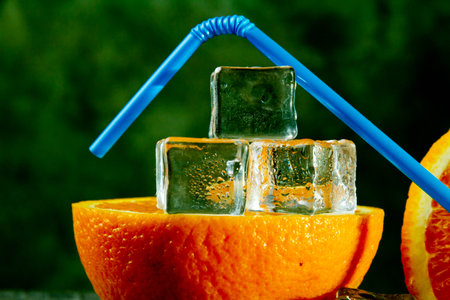 Orange with a straw for cocktails. Ice orange. Juice with ice.Orange drink. Copyspace.の写真素材