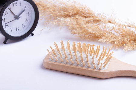 Time for hair care. Hours of taking vitamins for long hair. Comb and watch. Beauty and health of scalp hair.の写真素材