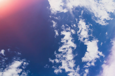 White clouds in bright sunlight. Sunrise. Revival of day. Clouds in glare of sun.