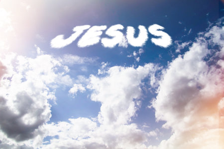 Jesus. Text from clouds in sky in bright sunlight..の写真素材