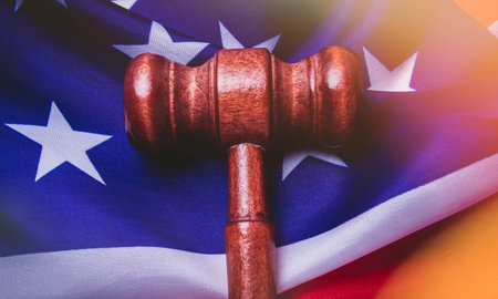 Justice in the USA. American Court. Sentencing the accused. The application of punishment to the guilty and the acquittal of the innocent. The jury in the courtroom and the judge. Hammer of the judge on the background of the usa flag.の写真素材