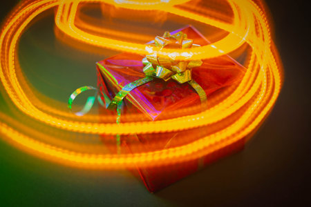 New Year's gift in a bright package against the background of Christmas decorations and bright...