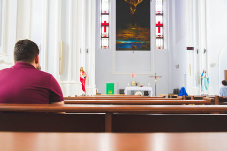 People pray in the church. Church parish. Believers sit on benches in the hall. Prayer time.の写真素材