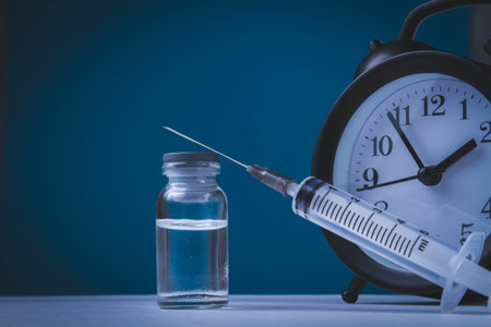 Time for vaccination. Watch and syringe with vaccine. Date and time of preventive vaccinations to population..の写真素材