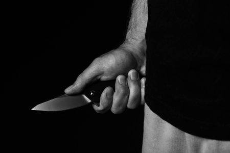 A sharp knife in the man's hand. The use of cold weapons. Knife attack . Armed raid..の写真素材