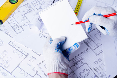The builder records the construction costs. Construction plan approval. Notepad in the hands of the...