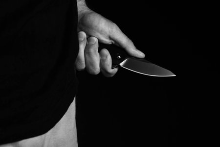 A sharp knife in the mans hand. The use of cold weapons. Knife attack . Armed raid..の写真素材
