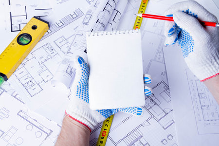 The builder records the construction costs. Construction plan approval. Notepad in the hands of the foreman..の写真素材