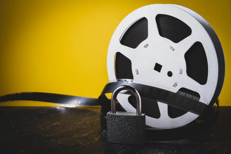 Old film. Cinema on reel. Analogue cinema. Movie on cassette. Yellow background closeup.の写真素材