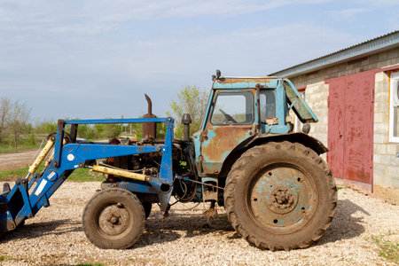 Tractor on the farm. Farmer's equipment. Blue tractor against the background of the village..の写真素材