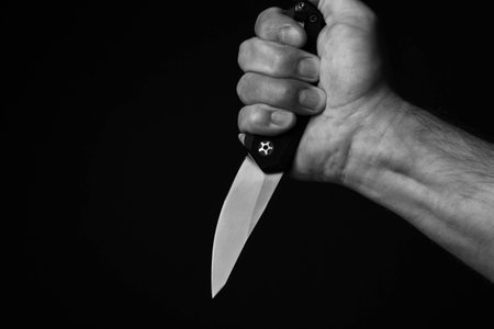 A sharp knife in the man's hand. The use of cold weapons. Knife attack . Armed raid..の写真素材