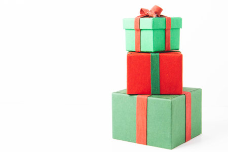 Present. Gift box with a bow. New Year's surprise. Red and green box with a gift. On a white background, top view. Close-up. Tied with a beautiful ribbon for gifting. Under the tree.の写真素材
