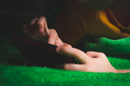 Phone in hands of child. Little boy playing mobile games on smartphone. Hand closeup..の写真素材