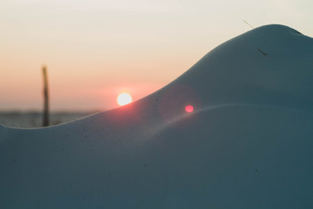 Frosty winter sunset in the field. Beautiful sunset in the snowy desert. Ice and sun..の写真素材