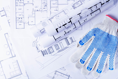 Builders tools on the scheme of the house. Preparing to build a house. Builders gloves and blueprints..の写真素材