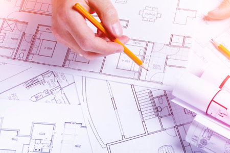 Builders hands on the background of a house plan. Construction planning. Drawing up an estimate..の写真素材