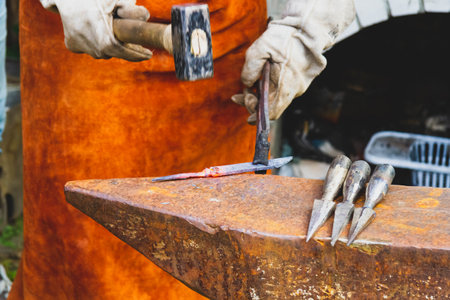 A blacksmith forges iron. Blacksmiths workshop. Blacksmiths anvil and hammer..の写真素材