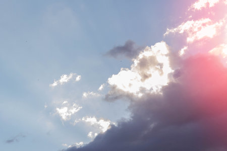 White clouds in bright sunlight. Sunrise. Revival of day. Clouds in glare of sun.の写真素材