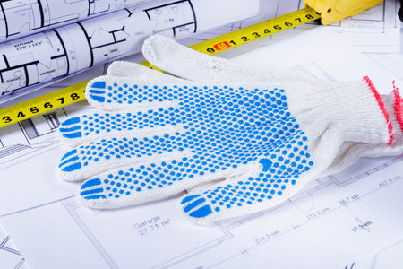 Builders tools on the scheme of the house. Preparing to build a house. Builders gloves and blueprints.の写真素材