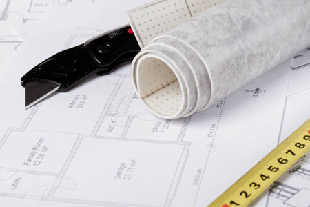 Laying flooring. Linoleum, a knife and a house plan on the builder's table. Taking measurements for...