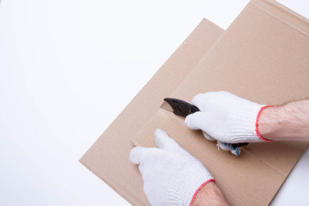Packing the goods in a cardboard box and stretch film. Tools for packing parcels at the post office..の写真素材