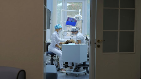 The concept of healthcare and medicine. Patient receiving dental treatment in dental office, dentist and assistant during teamworkの写真素材