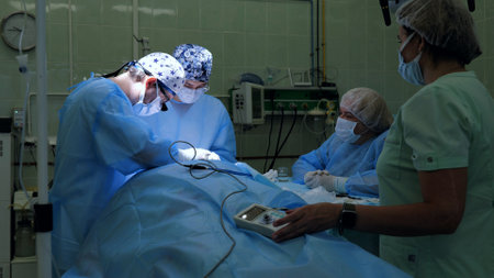 A team of professional doctors operating in a hospital ward. A team of surgeons perform facial nerve repair surgery. Team surgeon at work in the operating roomの写真素材