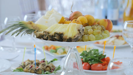 Fruit plate on the holiday table. Sliced pineapple and fruits in a fruit bowlの写真素材