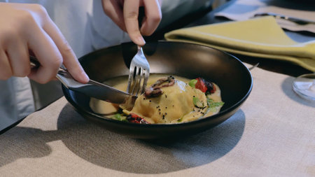 Close-up hands. Fish dish in dough. Signature dish in the restaurant. Dish and hands with cutlery close-upの写真素材