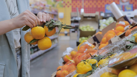 The girl chooses sweet citrus fruits in the supermarket, vitamins, healthy foodの写真素材