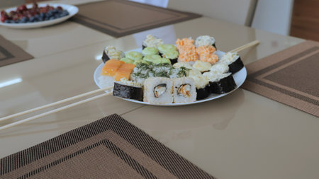 A huge number of types and options for food, as well as sushi with fruits and desserts. Various types of sushi on a white plate. Dinner for two with sushi and wine.の写真素材