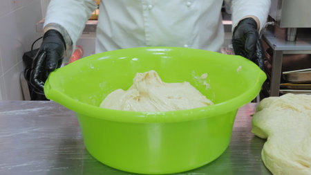 The chef is preparing the dough, the cook is working with the dough in the kitchen, the chefs are...