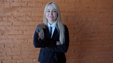 In front of brick wall caucasian woman in business suit with crossed arms women career success....