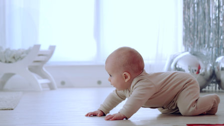 Baby crawls on the floor in a bright room adorned with festive decorations, delighting in their first christmas experienceの写真素材