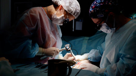 Skilled surgeons perform delicate operation in dimly lit room, showcasing teamwork and precision in healthcareの写真素材