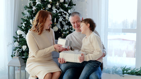 Family enjoying quality time and gift exchange during the festive season in their warm home. A day with family before Christmas. New Years Eve with familyの写真素材