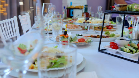 Professional catering team arranging sophisticated appetizers, canapes on pristine white plates,...